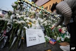 Una mujer coloca ofrenda floral a víctimas del mortal accidente en Seúl, Corea del Sur, en la noche de Halloween