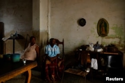 Nelly García, de 65 años, y su madre Enriqueta Pérez, de 91, toman aire fresco en la sala de estar de su casa después de que el huracán Rafael dejó sin servicio eléctrico al país a 10 millones de personas, en La Habana, Cuba, el 7 de noviembre de 2024. REUTERS/Norlys Perez