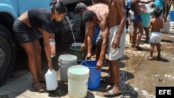 Cubanos se abastecen de agua en pipas.