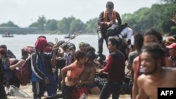 Miembros de la Caravana de Migrantes cruzan de Tecun Uman en Guatemala a Ciudad Hidalgo en México.