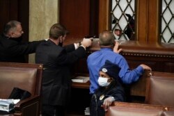 La policía con armas en la mano observa cómo los manifestantes intentan irrumpir en interior del Capitolio de los Estados Unidos, en Washington. (AP / J. Scott Applewhite)