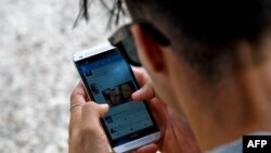 Un joven se conecta a Twitter desde su telefono en La Habana. (YAMIL LAGE / AFP)