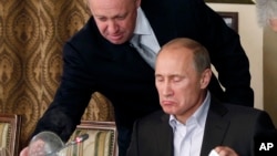 Yevgeny Prigozhin, arriba, sirve comida a Vladimir Putin en el restaurante de Prigozhin en las afueras de Moscú, en noviembre de 2011. (Foto AP/Archivo)