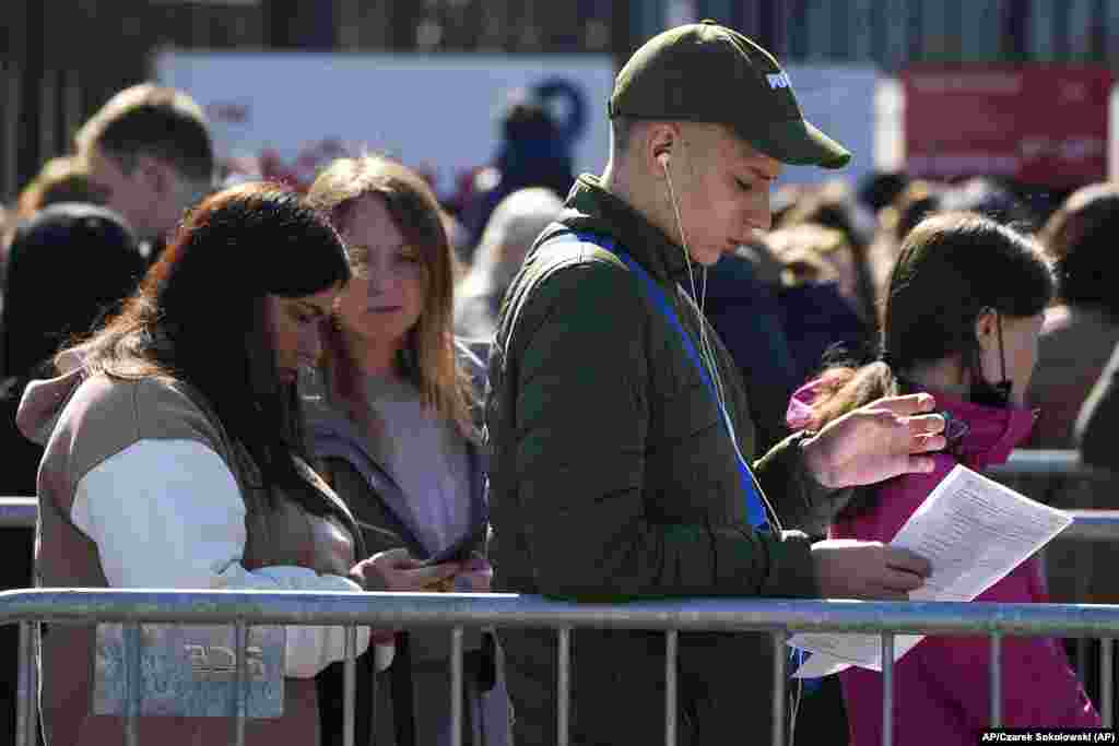 Las personas esperan en una cola en el Estadio Nacional de Varsovia en Polonia para poder aplicar por un número de Identificación polaca que los dejará trabajar, tener servicios médicos gratuitos y educación. Foto: AP/Czarek Sokolowski.