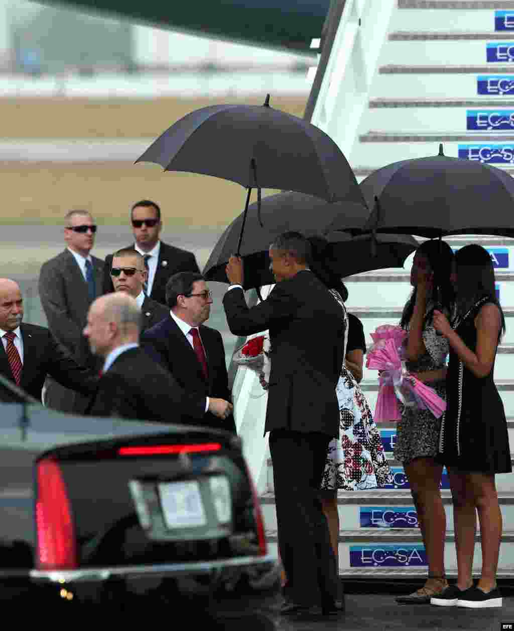 El presidente de Estados Unidos, Barack Obama, junto a su esposa Michelle Obama y sus hijas Malia y Sasha son recibidos por el canciller cubano Bruno Rodríguez, el 20 de marzo de 2016, en el aeropuerto José Martí de La Habana.